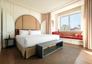 瓦伦西亚Only YOU Hotel Valencia的一间卧室配有一张大床和一张红色的沙发