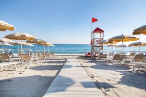 曼达托里乔码头天堂村酒店的海滩上设有椅子和遮阳伞,还有大海