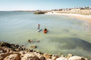 达赫拉Bavaro Beach Dakhla的两人在海滩上的冲浪板上