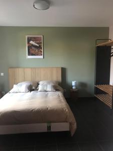 Saint-VidalL'Estampille的一间卧室设有一张床和绿色的墙壁