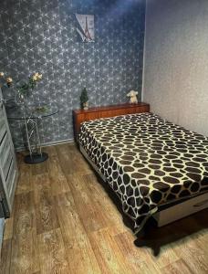 乌斯季卡缅诺戈尔斯克Квартира的一间卧室配有一张带黑白色棉被的床