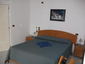 阿马尔菲拜亚德阿马尔菲假期酒店的一间卧室配有一张带蓝色棉被的床