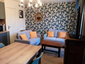 圣瓦斯特拉乌格Appartement de 2 chambres a Saint Vaast la Hougue a 200 m de la plage avec wifi的客厅配有蓝色的沙发和桌子