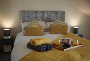 艾尔Ayr Loft Apartment with Fabulous Views的一张带毛巾托盘和饮料的床