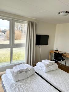 孔斯巴卡范德拉赫木纳特莫萨恩酒店的一间卧室配有两张床、一张桌子和一台电视。