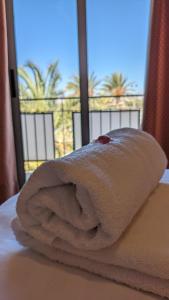 圣胡安·德·阿利坎特桑塔法兹酒店的床上的毛巾,带窗户