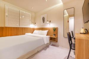 首尔Hotel Less Seoul的卧室配有一张白色大床和镜子
