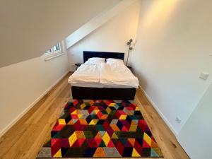 奥芬巴赫Apartment Lili-PS5-Terrace-View-Bright-Kitchen-2xBedroom的卧室配有一张带色彩缤纷地毯的床。
