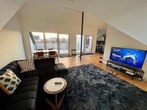 奥芬巴赫Apartment Lili-PS5-Terrace-View-Bright-Kitchen-2xBedroom的带沙发和平面电视的客厅