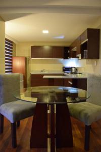 拉巴斯HB Apartament Sopocachi的厨房配有玻璃桌和两把椅子