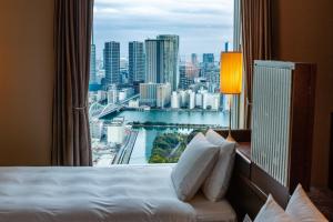 东京The Royal Park Hotel Iconic Tokyo Shiodome的酒店客房设有一个享有城市美景的窗户。