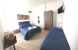 莱切La Dimora dei Professori DiffusHotel的一间卧室配有蓝色的床和沙发