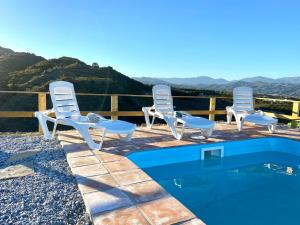 贝莱斯Casa El Barranco By Solymar Holiday的一组椅子坐在游泳池旁