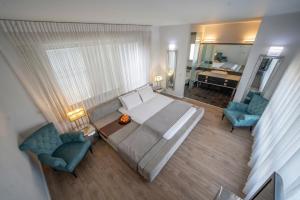 埃拉特Modern Villa-Ella Sun Eilat的一间卧室配有一张床、两把椅子和镜子