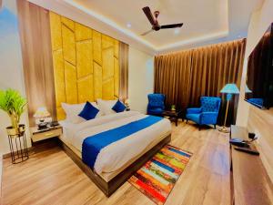 哈里瓦Gange Blossam, Haridwar的一间卧室配有一张特大号床和蓝色的椅子