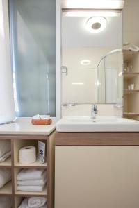贝尔格莱德赛尔加花园酒店的浴室配有盥洗盆、镜子和毛巾