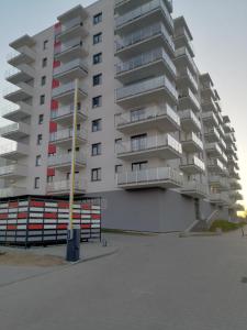 埃尔布隆格Apartament Mielczarskiego的停车场前高高的公寓楼