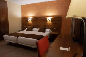 帕斯底拉卡萨Hotel Màgic Pas的一间卧室配有一张大床和木制床头板