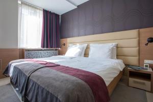 贝尔格莱德赛尔加花园酒店的一间卧室配有一张带白色床单的大床