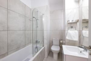 拉纳卡Solaar Apartments Faneromeni的带淋浴、卫生间和盥洗盆的浴室