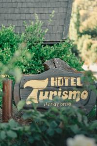 圣马丁德洛斯Hotel Turismo的花园中酒店标志