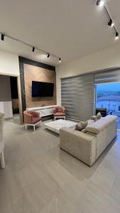 María ChiquitaAmazINN Places Playa Escondida SeaView的客厅配有2张沙发和1台平面电视
