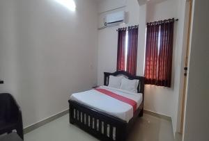 希莫加STAYMAKER Anjaneya Comforts的一间小卧室,配有红色窗帘