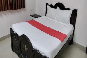 希莫加STAYMAKER Anjaneya Comforts的一间卧室,床上铺有红色条纹的床