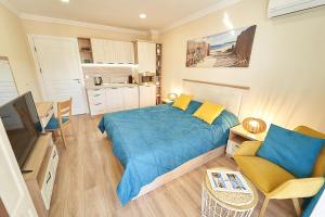布尔加斯Burgas Beach Resort Apartments的一间带蓝色床的卧室和一间厨房
