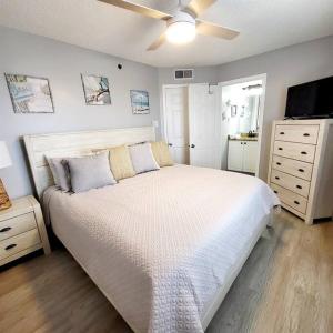 奥兰治比奇Tradewinds 808 - NEW Rental- 1bd/2bath-Luxury Comfort的一间卧室配有一张大床和吊扇