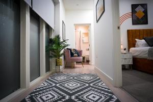 斯蒂夫尼奇Spacious Luxury Apartment in Stevenage, Sleeps 6, with Free Parking, and Free Wi-Fi的走廊上设有卧室,卧室配有床和地毯
