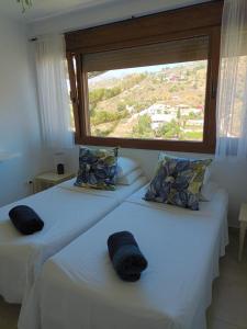 托罗克斯莱卡萨酒店的带大窗户的客房内的两张床