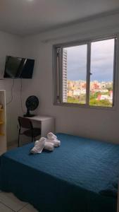 阿雷格里港Apto do Thiago e da Chori的卧室配有带2条毛巾的窗户,位于床上