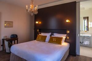 瓦隆蓬达克Hôtel Villa Walbaum的一间卧室配有一张大床和一个吊灯。