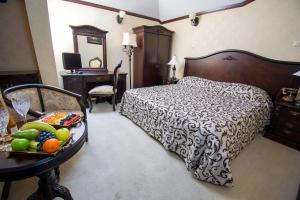 康斯坦察卡罗尔酒店的一间卧室配有一张床和一张带水果的桌子