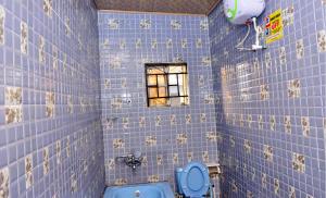 AwoyayaThe Agore Hotels and Suites Ltd的蓝色瓷砖浴室设有卫生间和窗户