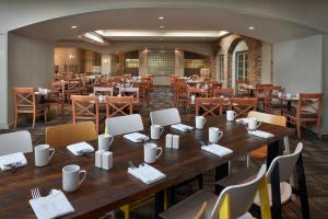 多伦多多伦多机场和会议中心万豪德尔塔酒店的餐厅设有一张大型木桌和椅子