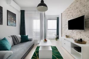 卢布林Easy Rent Apartments - Metropolitan 75的客厅配有沙发和砖墙电视
