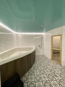 利沃夫Апартаменти Underground&SPA的带浴缸的浴室和瓷砖地板。