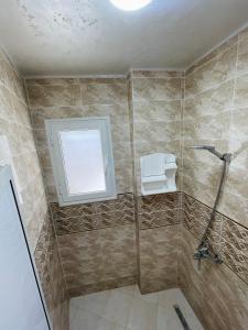 Ghār al MilḩSeaside Guest House的带淋浴、卫生间和窗户的浴室