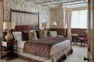 切尔滕纳姆艾伦博霍公园酒店的酒店客房带一张大床和一把椅子