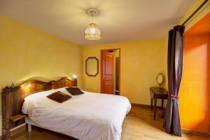 RoiseyLe clos du martouret的一间卧室配有一张带白色床单和黄色墙壁的床。