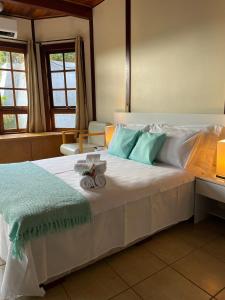 伊加拉塔Chalé das Águas的一间卧室配有一张带蓝白色枕头的大床