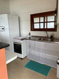 伊加拉塔Chalé das Águas的厨房配有白色冰箱和水槽