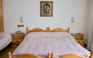 福尔尼阿沃尔特里Albergo Piani di Luzza的一间卧室配有木床和2个床头柜