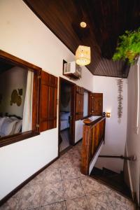 帕拉蒂Samburá Paraty的走廊上设有一张床和镜子的房间