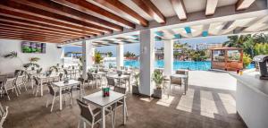 甘迪亚海滩富埃特文图公主酒店的一间带桌椅的餐厅和一个游泳池