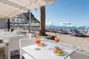 莫甘Mogan Princess & Beach Club的海滩上的餐桌,包括食物和饮料