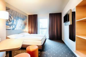 埃姆登B&B Hotel Emden的一间酒店客房,设有两张床和电视