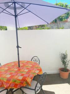 卡普里Cataldo Guest House的庭院内桌椅和遮阳伞